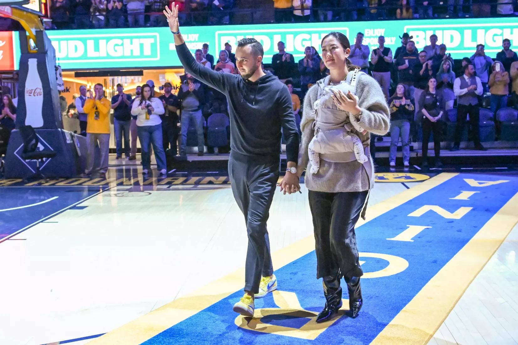 Jonnie West and wife Michelle walk the carpet at halftime.