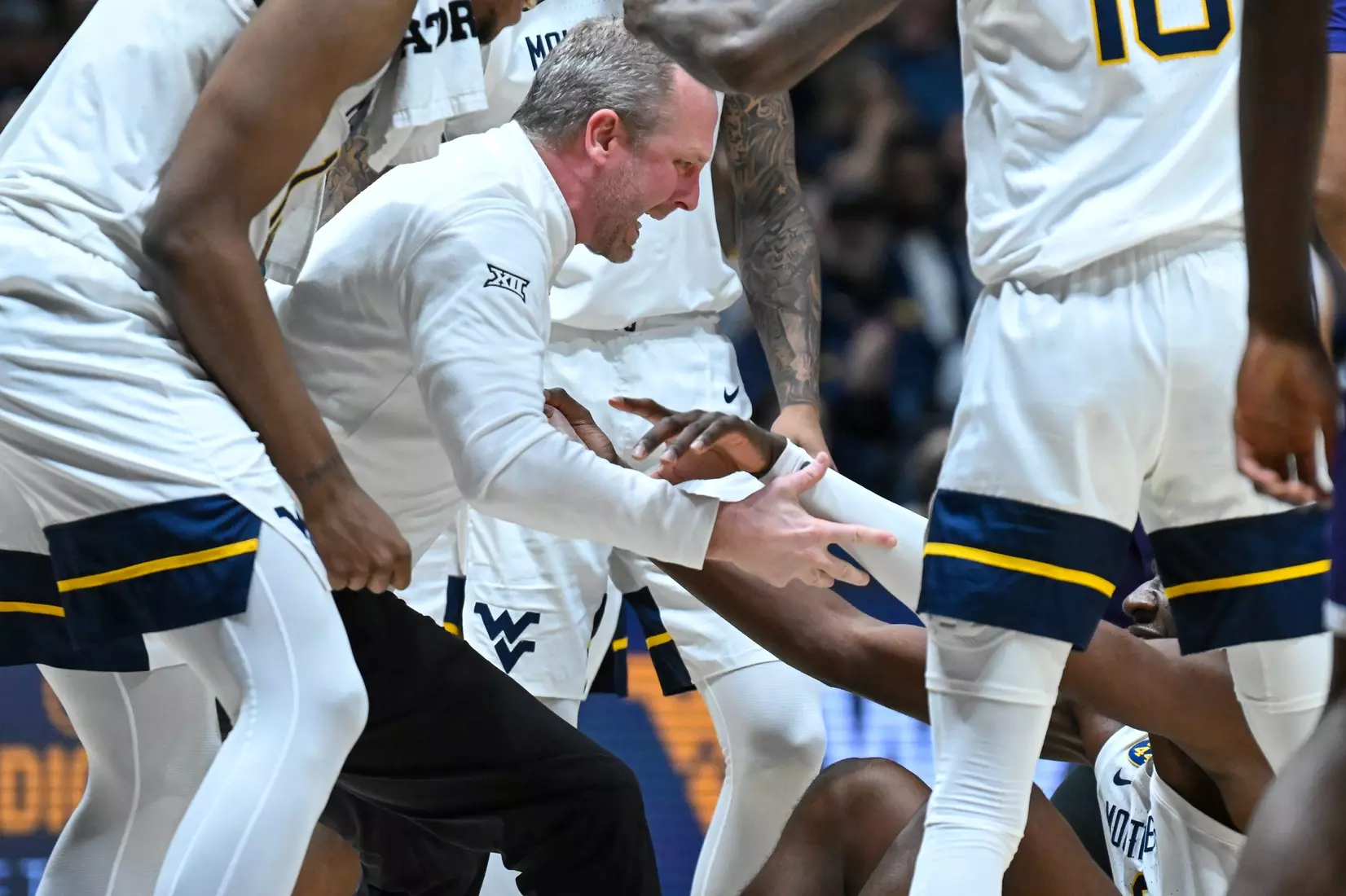 Head coach Darian DeVries helps up Eduardo Andre after a big play.