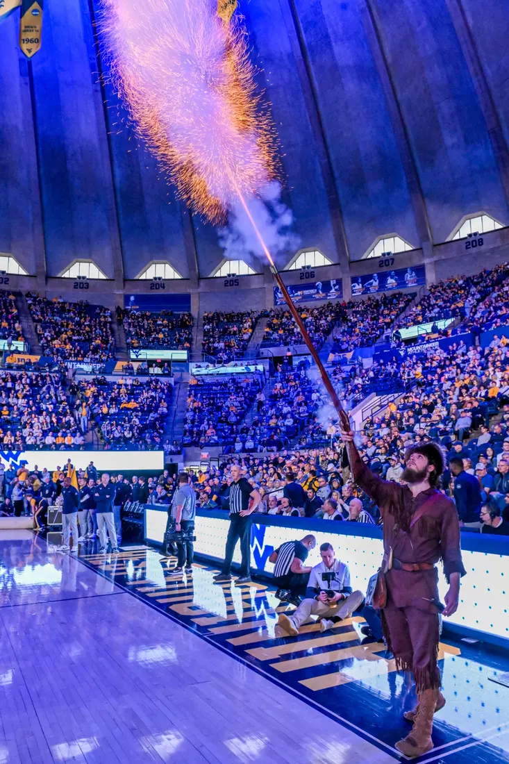 The Mountaineer mascot Braden Adkins fires his musket.