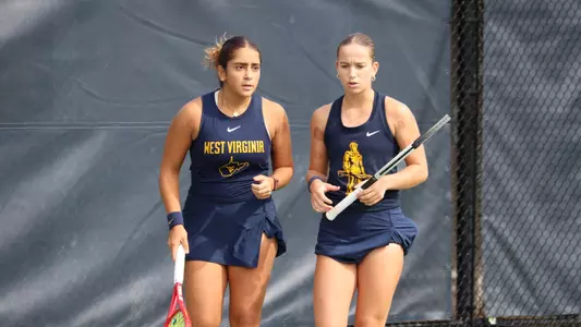 Sorana Matis and Sosanna Malaak talk after a point during a doubles match