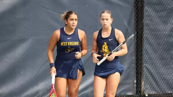 Sorana Matis and Sosanna Malaak talk after a point during a doubles match