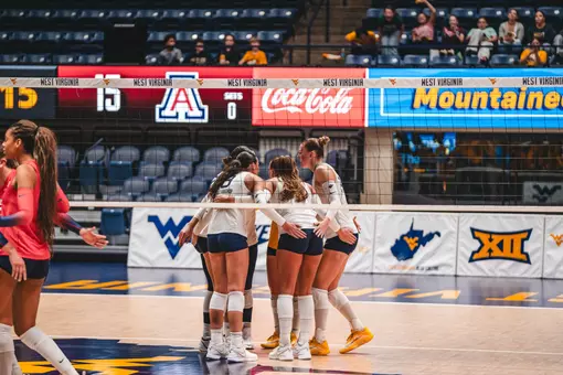 WVU Volleyball team huddles before a point against Arizona