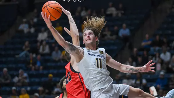 Guard Finley Bizjack scores a basket during West Virginia's exhibition game victory over Wheeling University Wednesday night at Hope Coliseum.