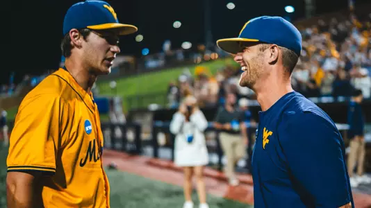 West Virginia coach Steve Sabins greets pitcher Ben McDougal after his five-inning relief appearance kept the Mountaineers' postseason hopes alive in their 11-9 come-from-behind victory over Kentucky to set up a deciding game five Monday in Morgantown.,
