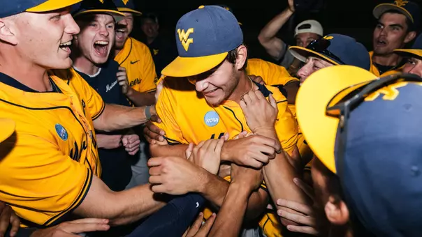 West Virginia players celebrate winning pitcher Ben McDougal's five-inning relief stint in the Mountaineers' 11-9 victory over Kentucky to set up a deciding game five on Monday at Kendrick Family Ballpark in Morgantown, W.Va.