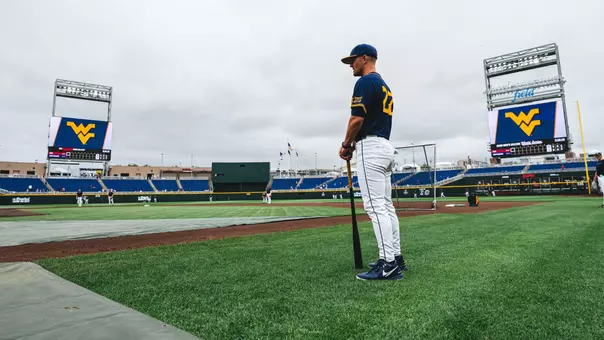 West Virginia coach Steve Sabins observes his team practicing at Charles Schwab Field in Omaha, Nebraska, on the eve of West Virginia's first-ever College World Series game against Troy on Friday, June 12, 2026.