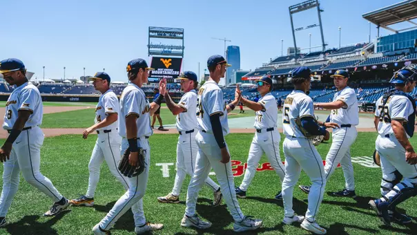 WVU baseball players high five before game against North Carolina