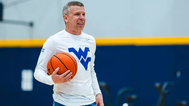 Wet Virginia coach Ross Hodge observes a summer workout inside the Basketball Practice Facility.