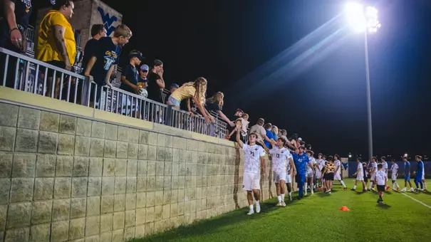 Men's Soccer players high five fans after defeating Pitt in an exhibition game
