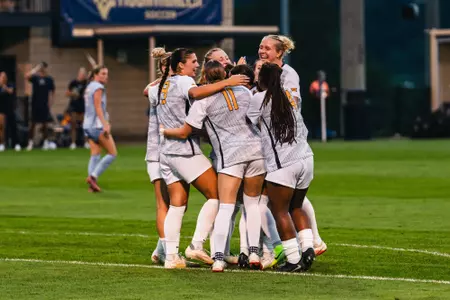Members of the WVU women's soccer team celebrate after a goal on Aug. 13, 2026.