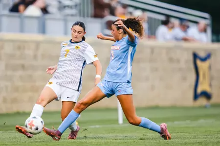 Alexis Pashales of the WVU women's soccer team battles for a ball against a Dayton defender during a match on Aug. 13 in Morgantown.