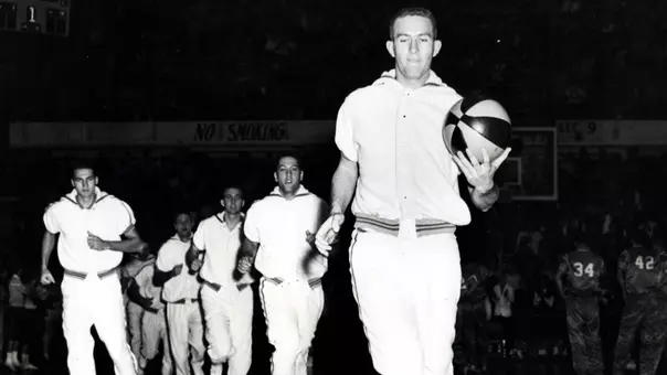 Team captain Willie Akers leads the Mountaineer basketball team out for pregame warmups during a college basketball game at the old Field House in 1960.