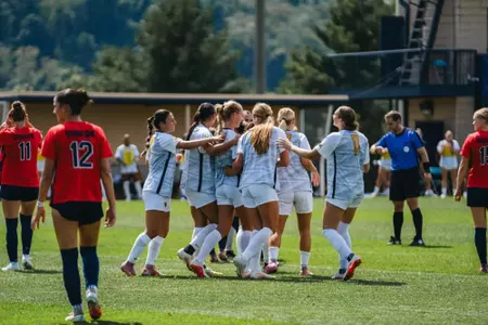 WVU women's soccer players celebrate a goal against Duquesne on Aug. 23.