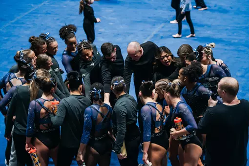 The WVU gymnastics team huddles after a meet at Hope Coliseum in 2026.