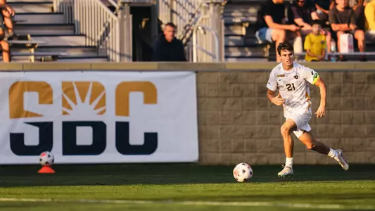 Isaac Scheer dribbles the ball against St. Bonaventure
