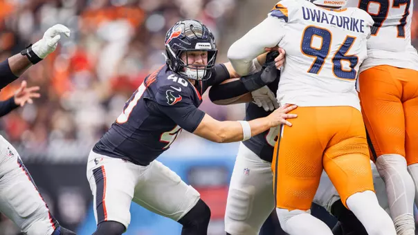 Austin Brinkman blocks a player in an NFL game against Denver