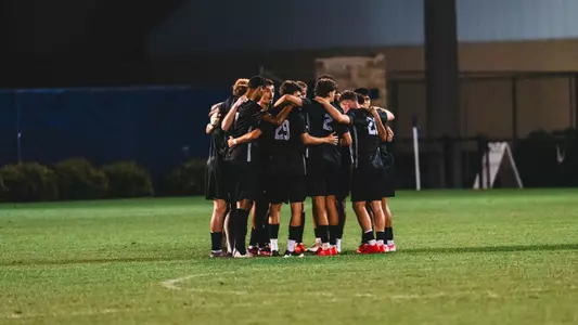 The WVU men's soccer team huddles up in a game against Denver