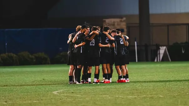 The WVU men's soccer team huddles up in a game against Denver