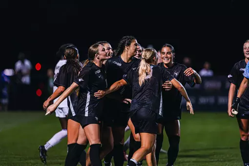 Members of the WVU women's soccer team celebrate after a goal.