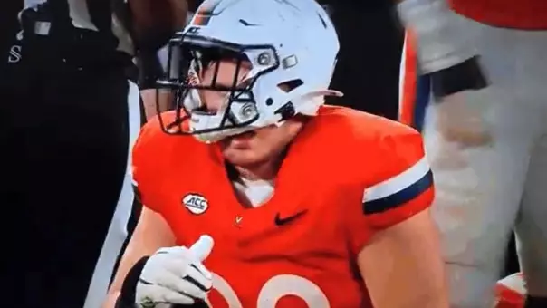 A dazed Virginia tight end John Rogers getting up after being hit by West Virginia defensive back Nick Taylor in the third quarter of Saturday's game at Bank of America Stadium in Charlotte, North Carolina.