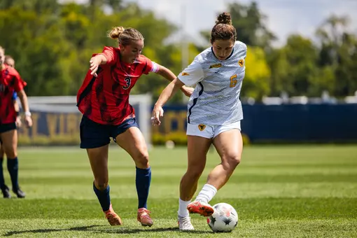 Maya Leoni dribbles a ball during a women's soccer game.