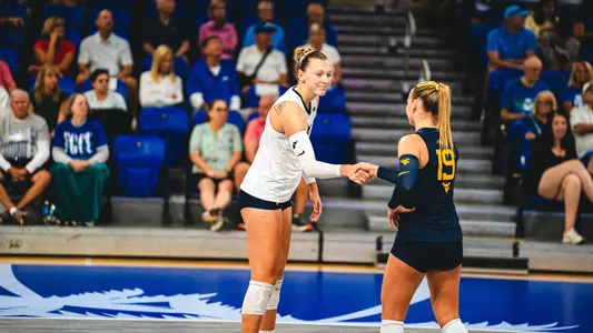 Nina Horning and Reagan Turk shake hands after winning a point against FGCU