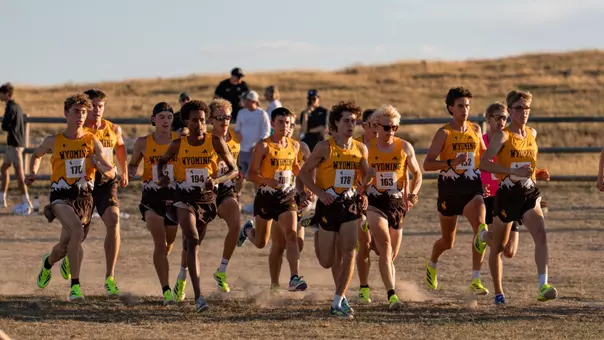 Men's cross country team running at the start line at the Wyoming Invite