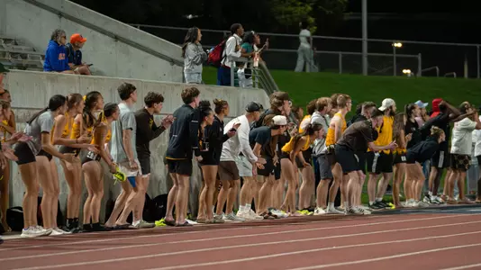 Track & Field team cheering on the 4x400-meter relays alongside the track