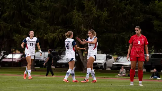 Alyssa Glover and Isabel Vasco celebrate after a goal against South Dakota at the Madrid Sports Complex