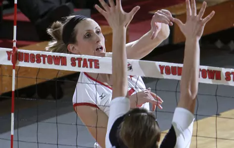 Tasha Reid attacks a ball at a volleyball net over a defender