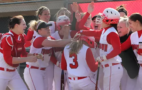 Group photo of the YSU softball team celebrating a home run