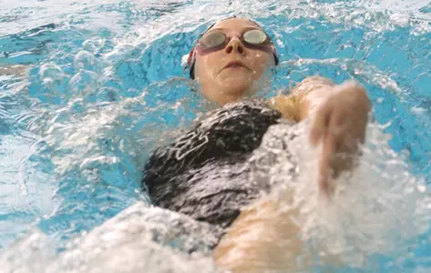 YSU female swimmer doing the backstroke