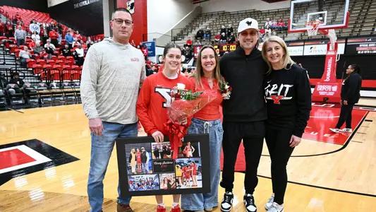 Casey Santoro stands with her father, mother, brother and Head Coach Melissa Jackson for senior day.