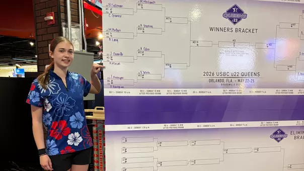 Amber Mason points to her name while standing next to the bracket of the U22 Queens event.