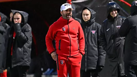 Head Coach Rich Wall paces on the sideline during a night game at Farmers National Bank Field