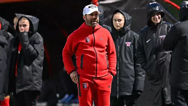 Head Coach Rich Wall paces on the sideline during a night game at Farmers National Bank Field