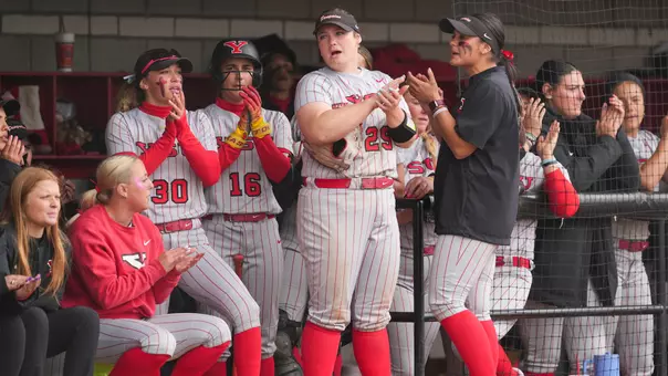 Members of Youngstown State's softball team cheer from the dugout