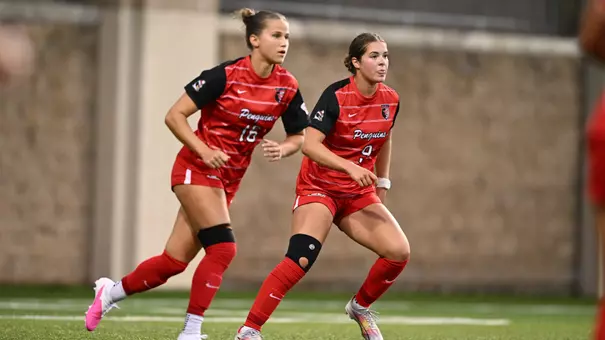 Women's soccer players Sara Felder and Kate Makkas on the field against Pittsburgh
