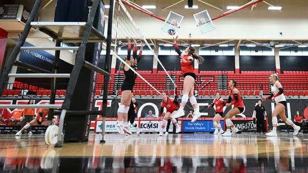Low-angle side view as Izzy Henry elevates to tip a ball at the net for the Youngstown State volleyball team against Findlay.